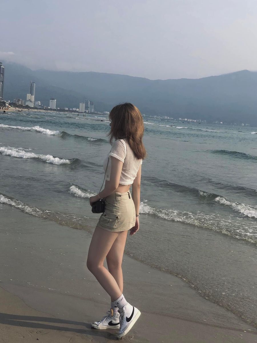 Gái xinh mặc áo crop top và chân váy ngắn bên bờ biển