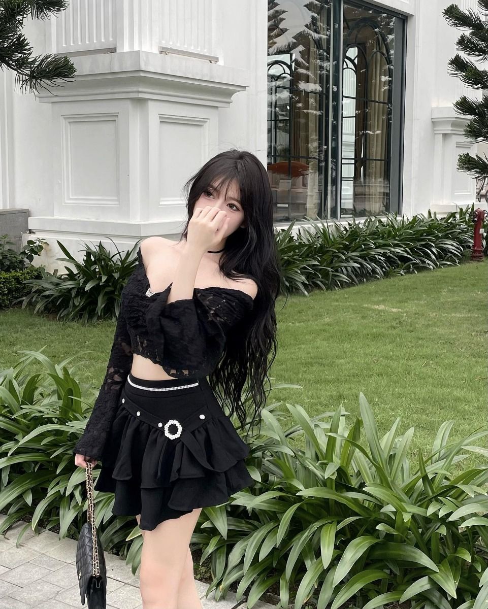 Gái xinh mặc áo croptop đen và váy xòe giữa rừng cây xanh