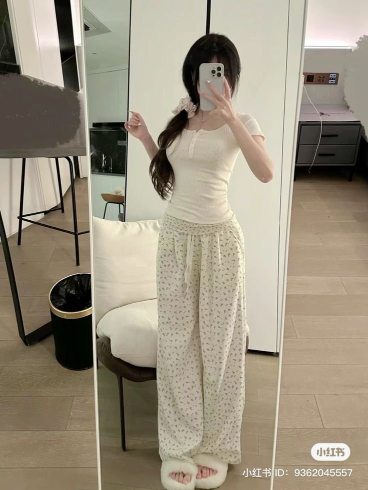 Gái xinh mặc áo dài trắng và quần dài họa tiết trước gương
