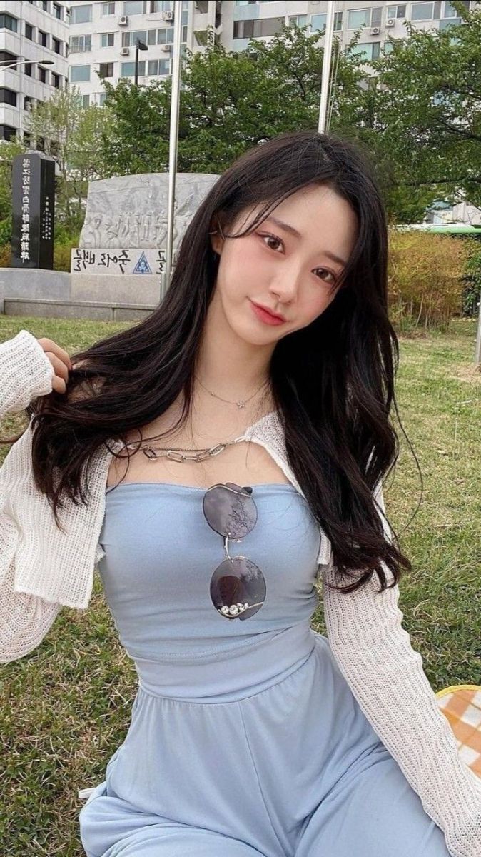 Gái xinh mặc áo hai dây màu xanh và cardigan trắng