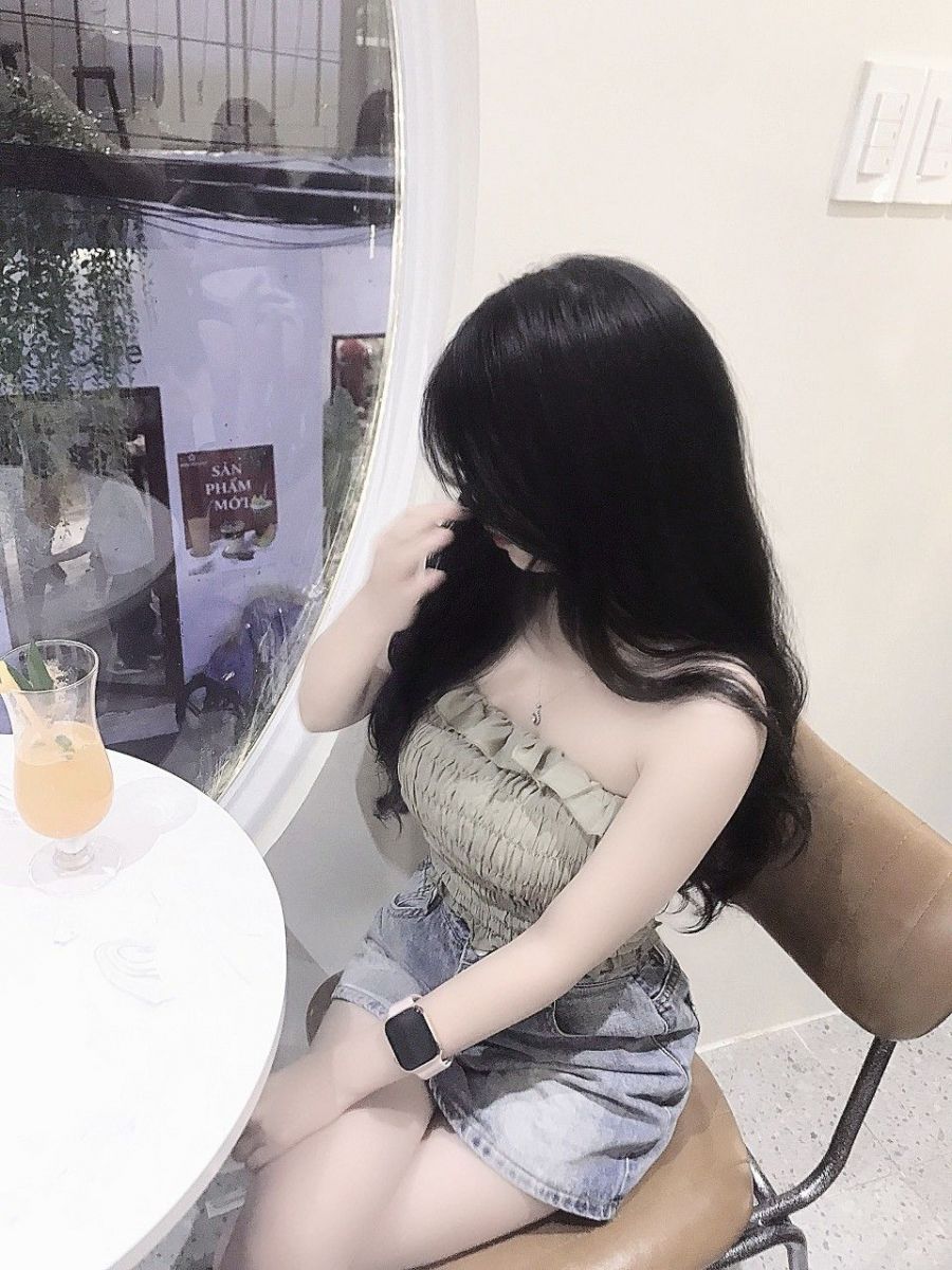 Gái xinh mặc áo hai dây màu xanh và chân váy jeans quyến rũ