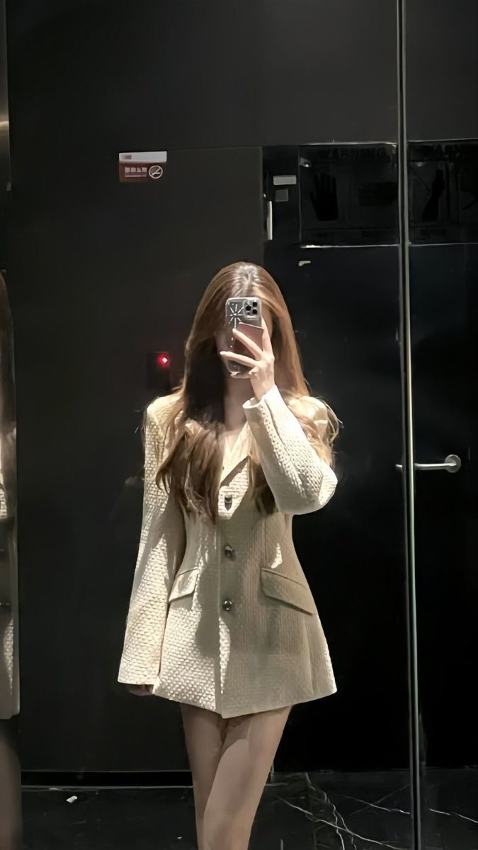 Gái xinh mặc áo khoác oversize màu kem chụp selfie