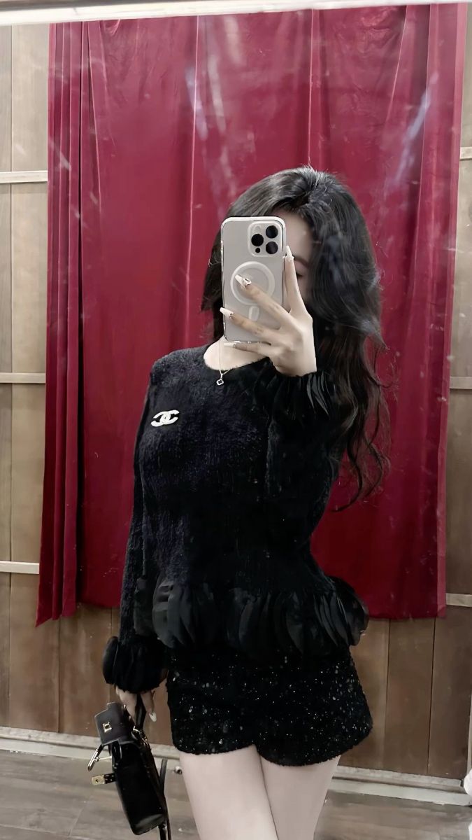 Gái xinh mặc áo len đen và quần short đen chụp selfie trong gương