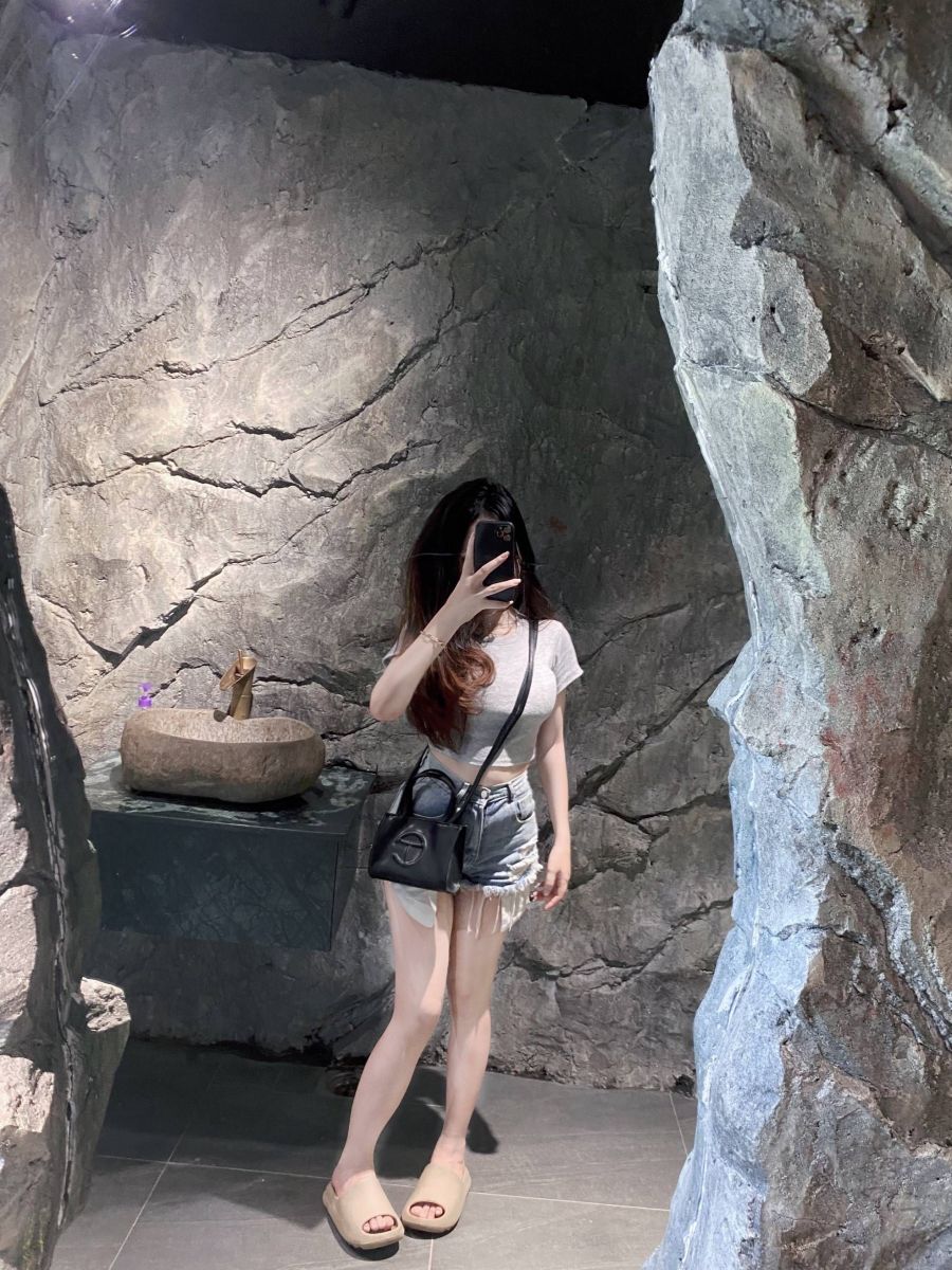 Gái xinh mặc áo phông xám và shorts jeans rách