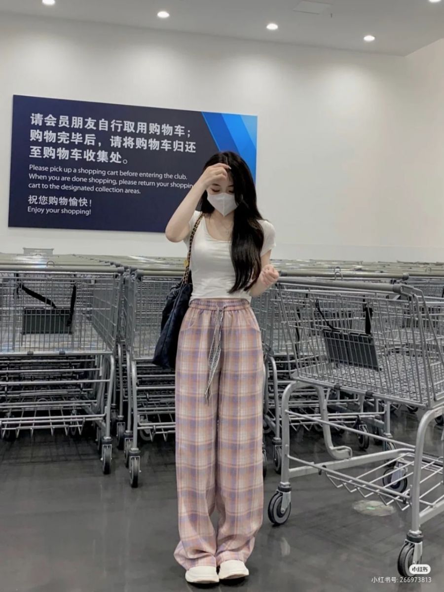 Gái xinh mặc áo thun trắng và quần sọc rông tại siêu thị