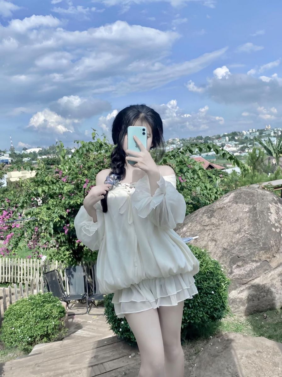 Gái xinh mặc áo trắng và chân váy ngắn giữa khu vườn xanh