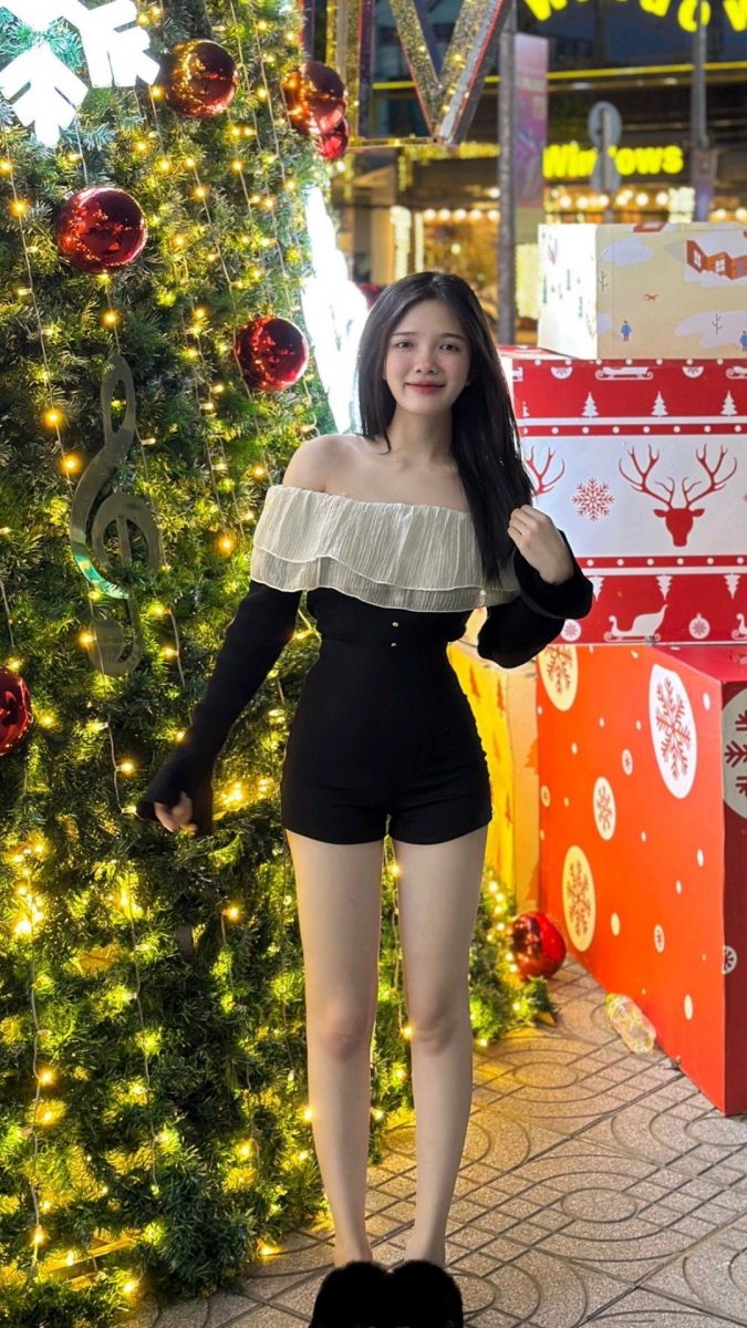 Gái xinh mặc bộ đồ ngắn màu đen bên cây thông Noel
