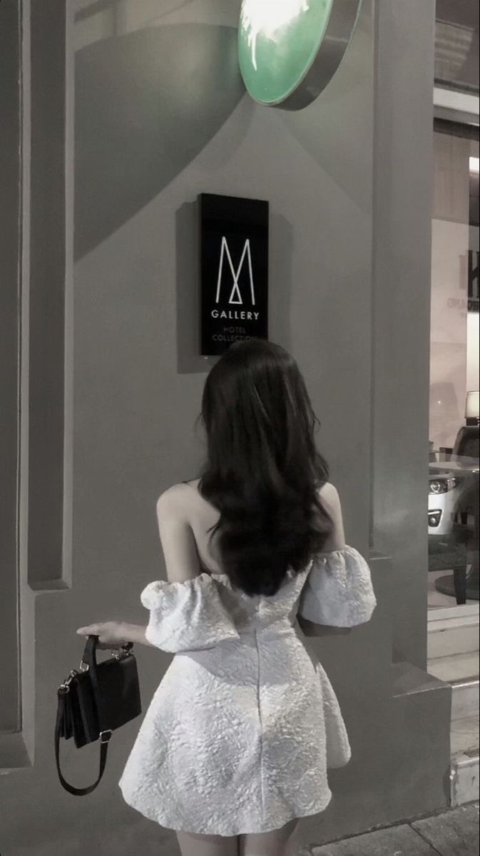 Gái xinh mặc đầm trắng đứng quay lưng nhìn vào biển