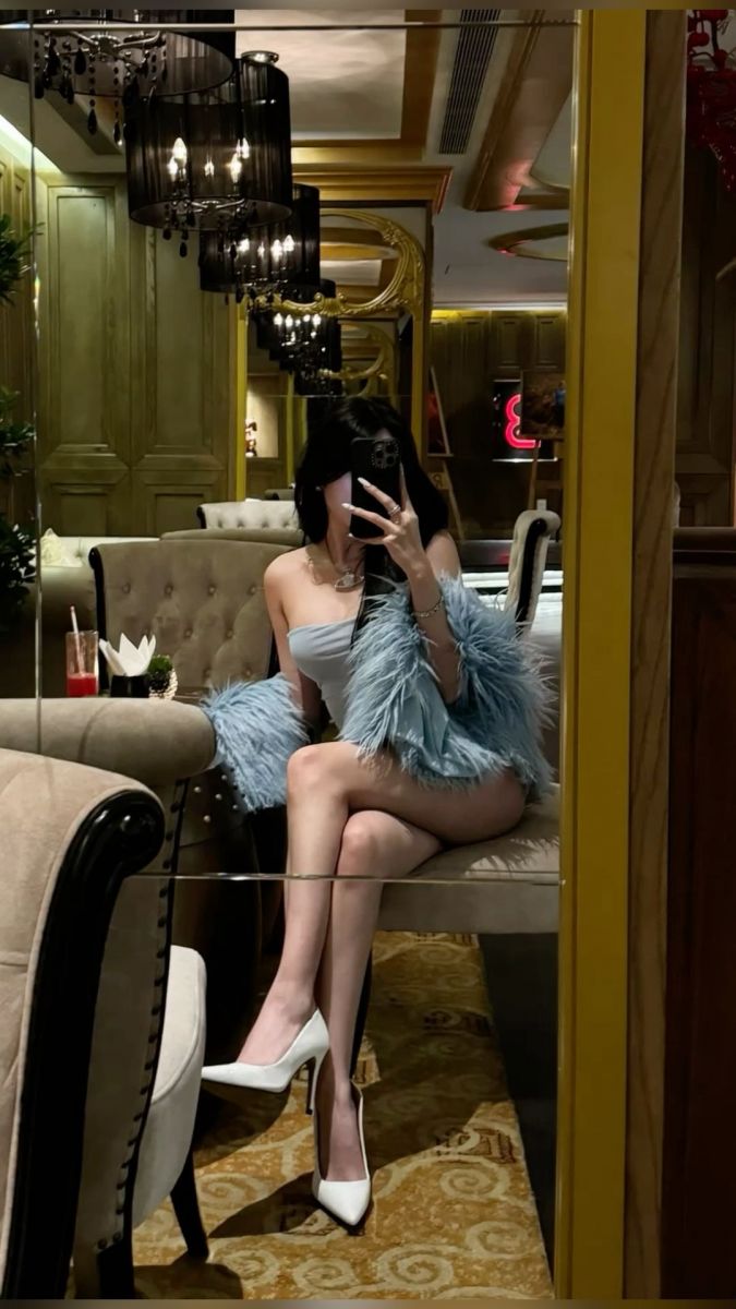 Gái xinh mặc hở với áo khoác long màu xanh trong quán cà phê sang trọng