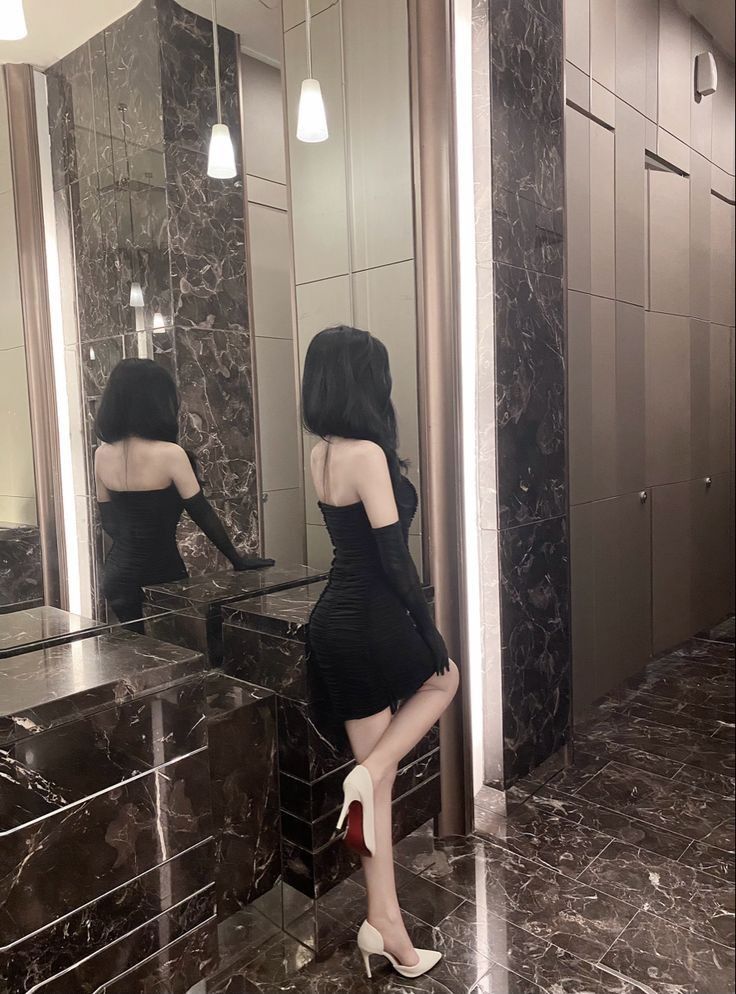 Gái xinh mặc váy ôm màu đen bên cạnh gương đẹp