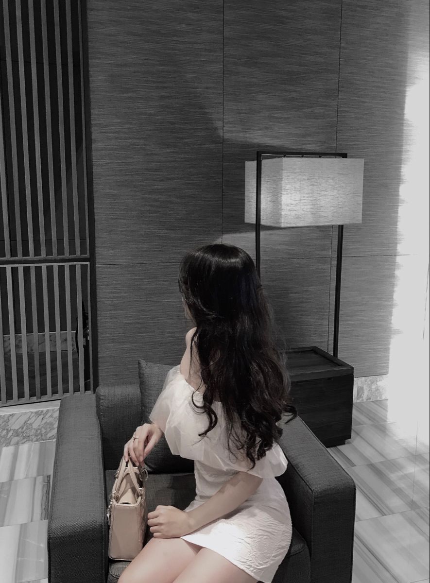 Gái xinh mặc váy trắng ngồi trên ghế sofa hiện đại