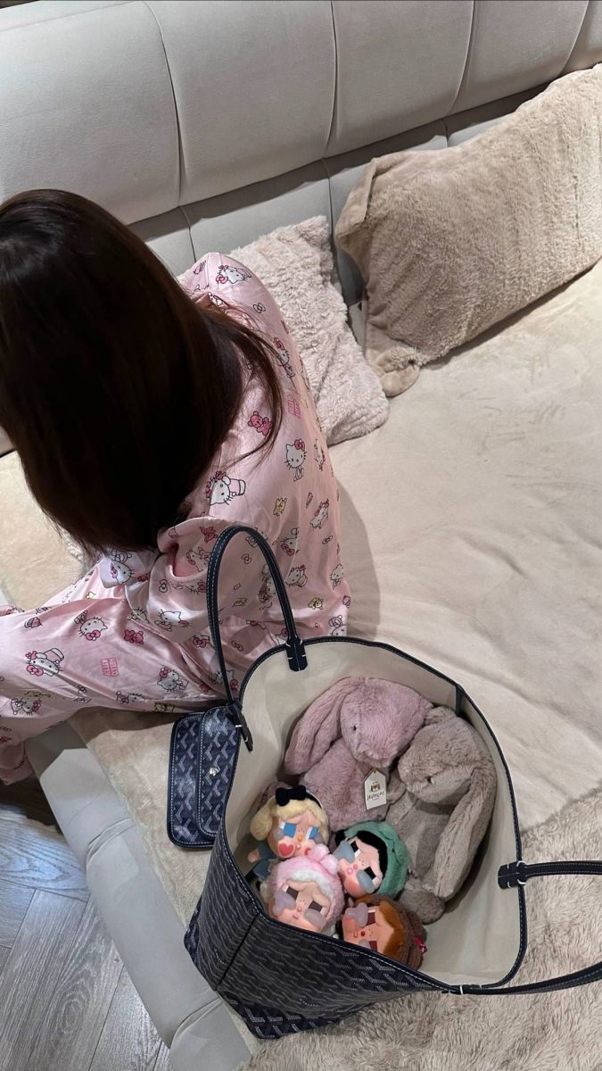 Gái xinh ngồi trên giường với túi đồ chơi