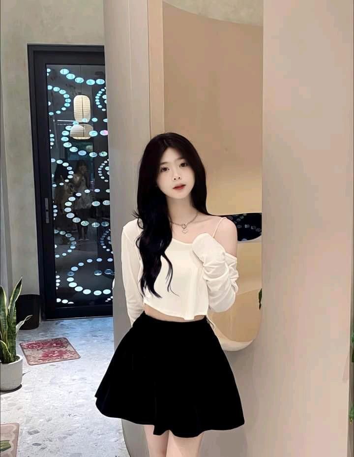 Gái xinh trong áo crop top trắng và chân váy đen tại quán cà phê hiện đại