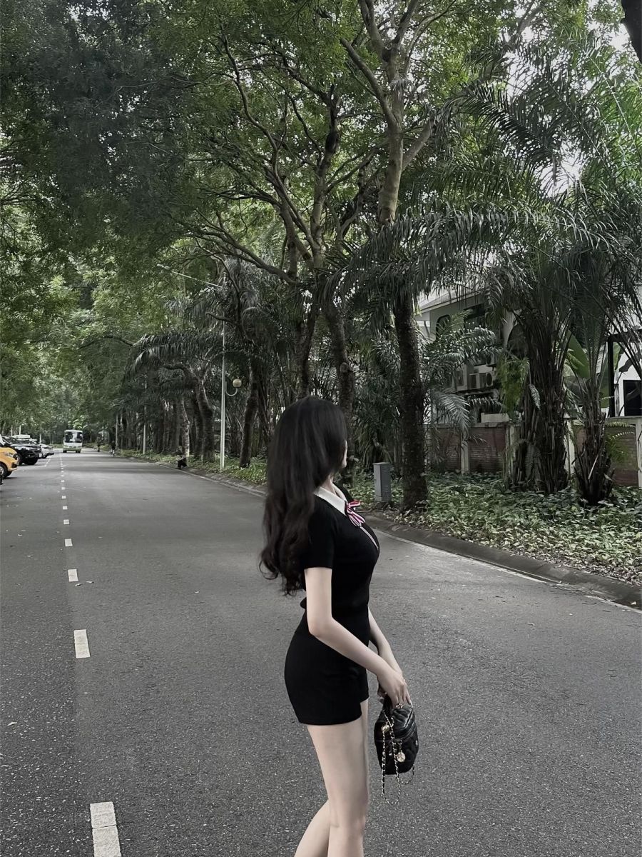 Gái xinh trong áo dress ngắn màu đen giữa phố vàng
