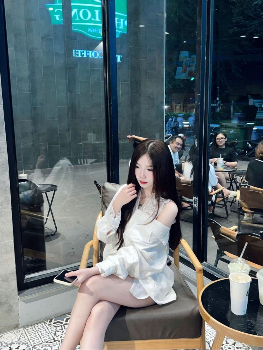 Gái xinh trong áo sơ mi trắng tại quán cà phê hiện đại