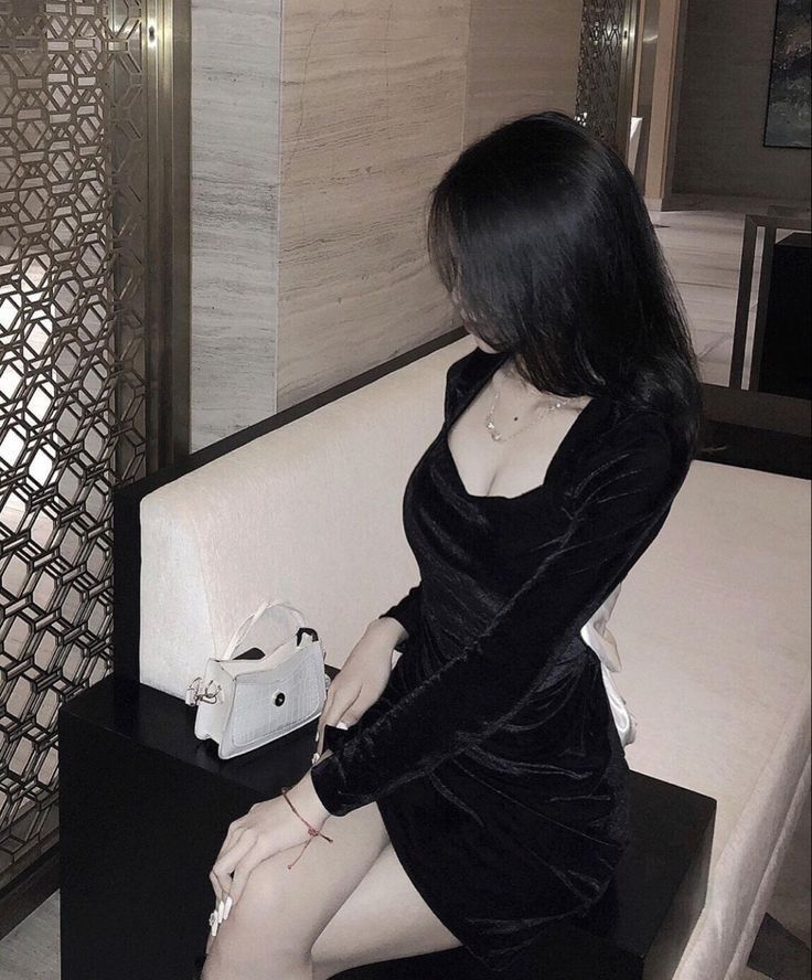 Gái xinh trong bộ váy đen ngồi bên ghế sofa sang trọng