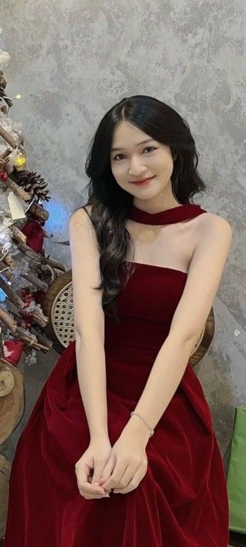Gái xinh trong bộ váy đỏ ngồi trên ghế tay đặt trên đùi