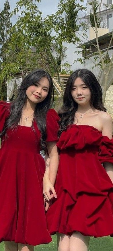 Hai cô gái mặc váy đỏ giống nhau chụp ảnh ngoài trời