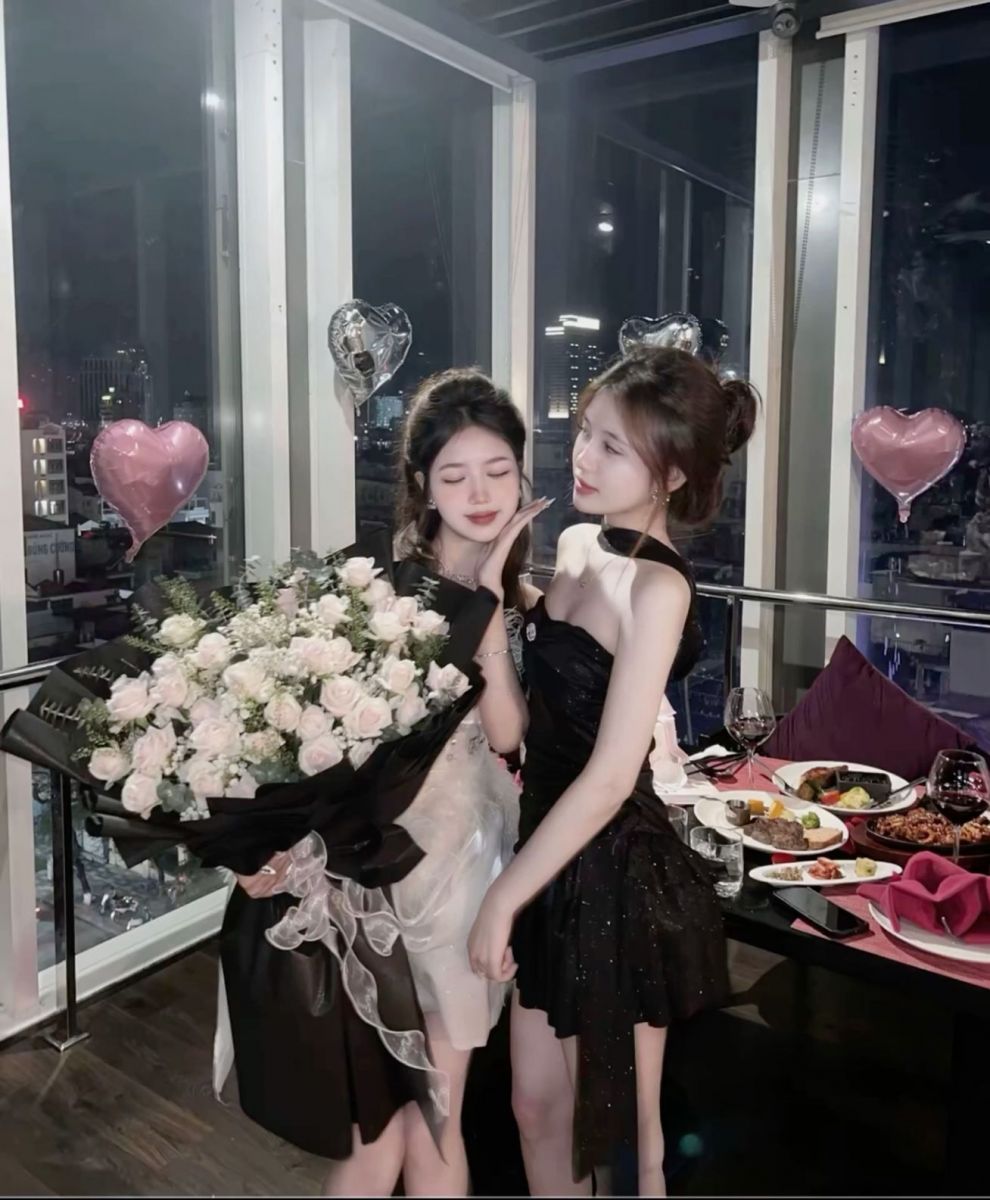 Hai cô gái mặc váy trắng và đen đứng cạnh nhau