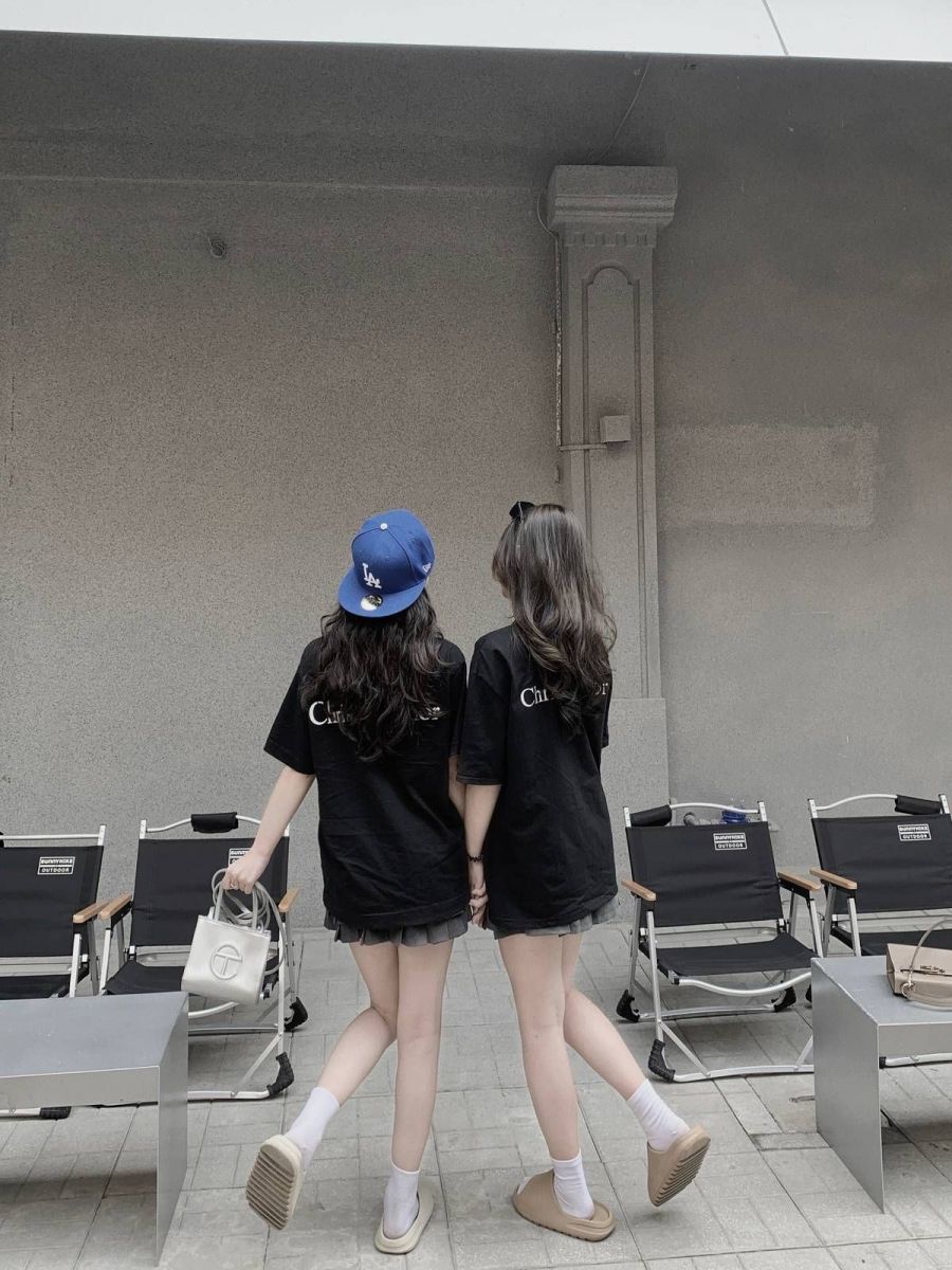 Hai cô gái trẻ mặc áo phông đen oversized và quần ngắn