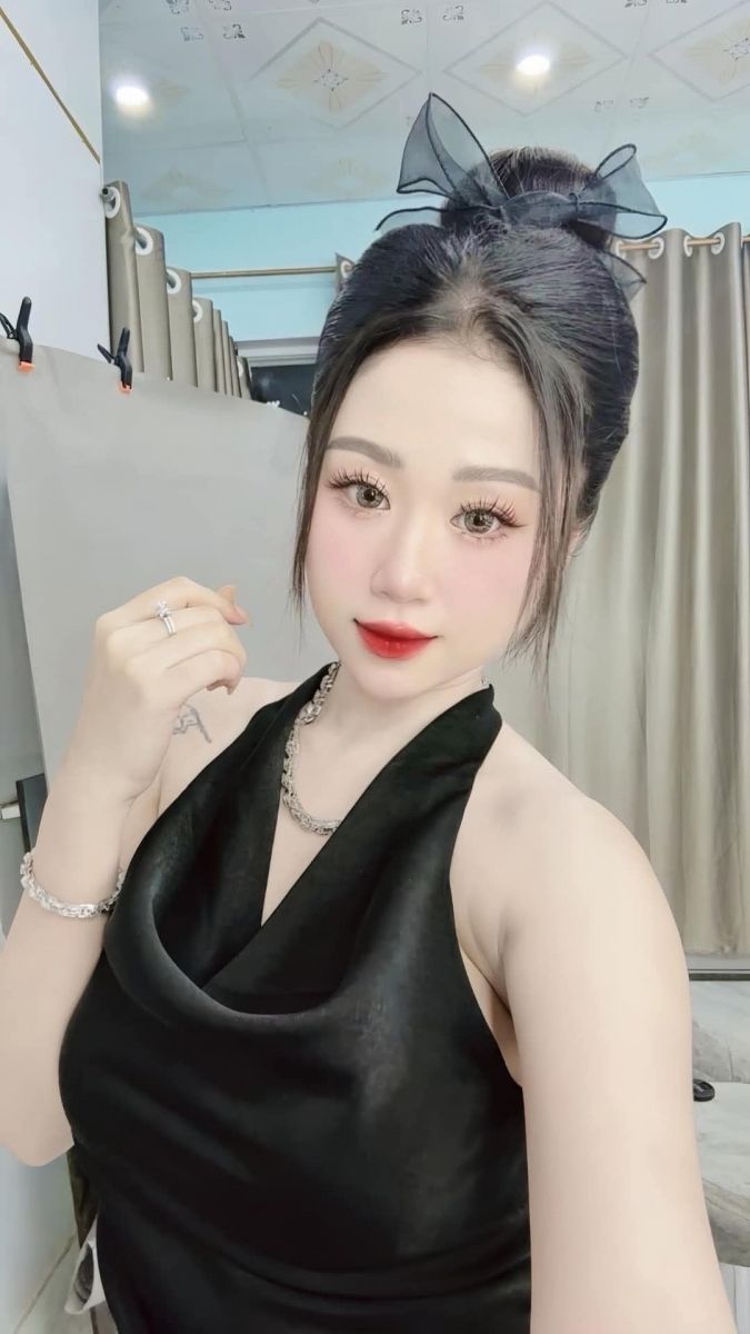 Nữ mặc váy đen tạo dáng chụp ảnh trong không gian nội thất gọn gàng
