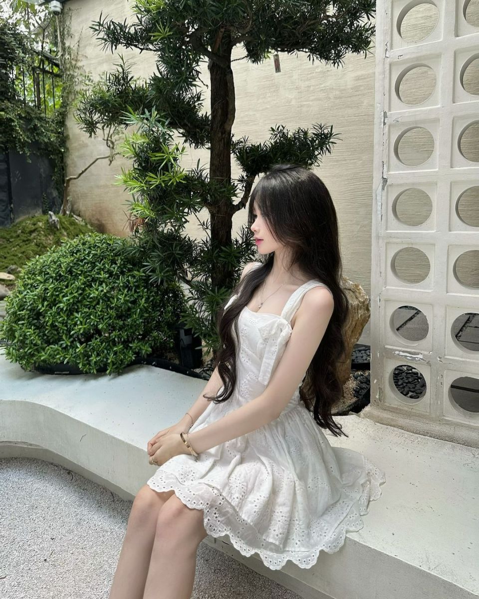 Cô Gái Mặc Váy Trắng Ngồi Trên Ghế Đá Trong Vườn