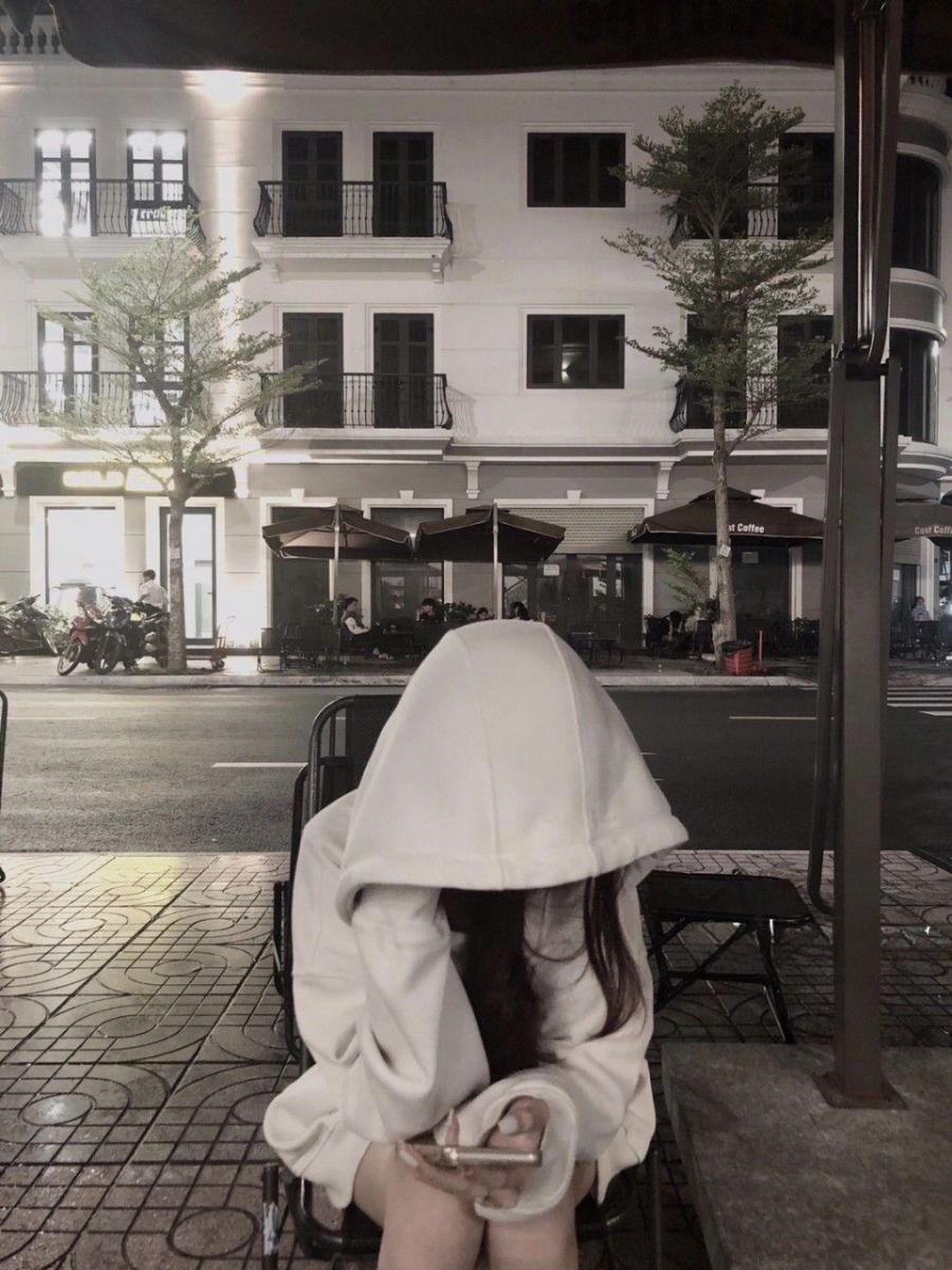 Gái Mặc Áo Hoodie Trắng Ngồi Cùi Đầu Trên Ghế