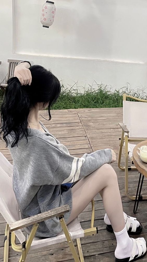 Gái Mặc Áo Khoác Xám Ngồi Trên Ghế Gỗ