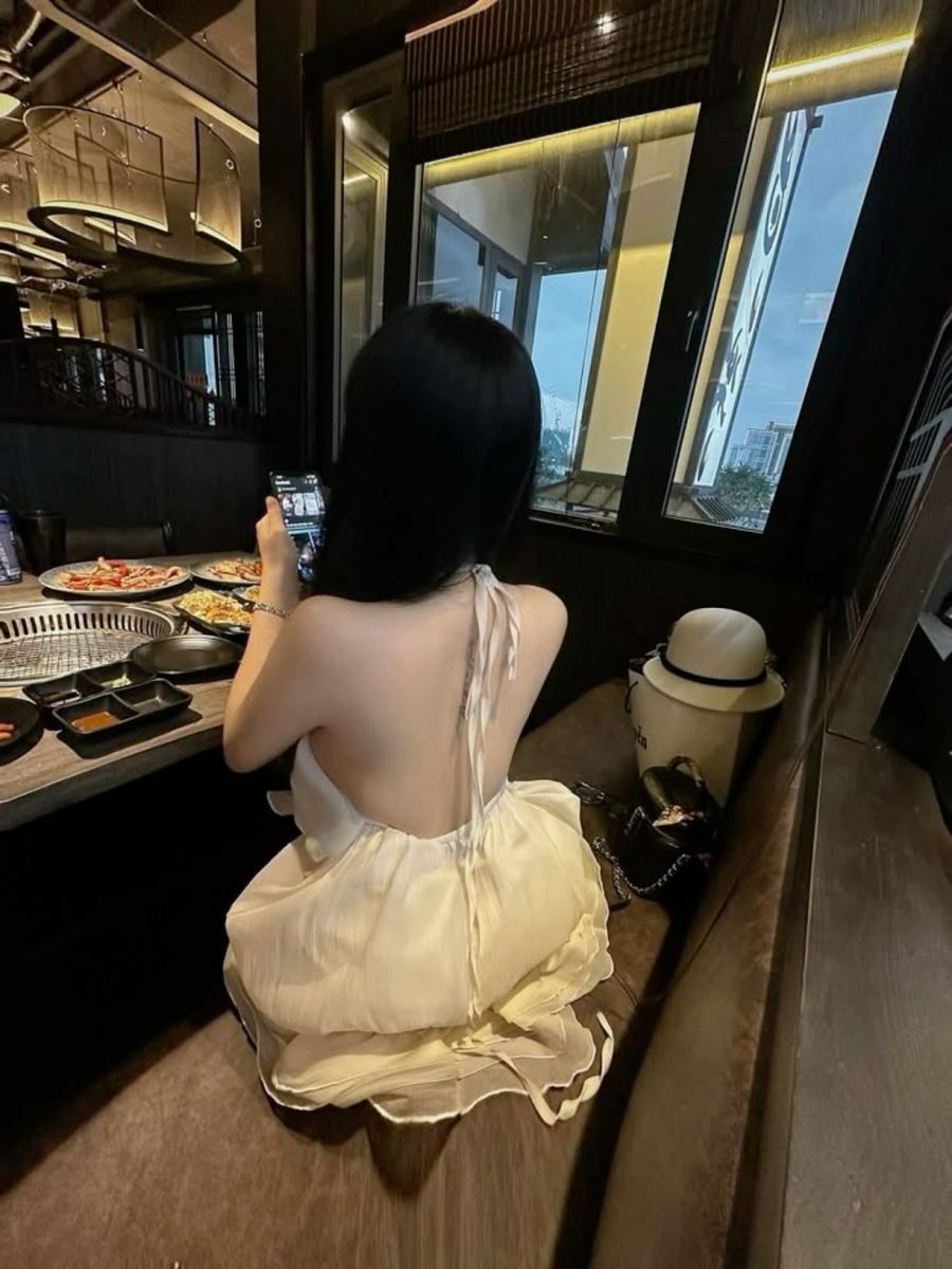 Gái Mặc Váy Trắng Ngồi Tại Nhà Hàng
