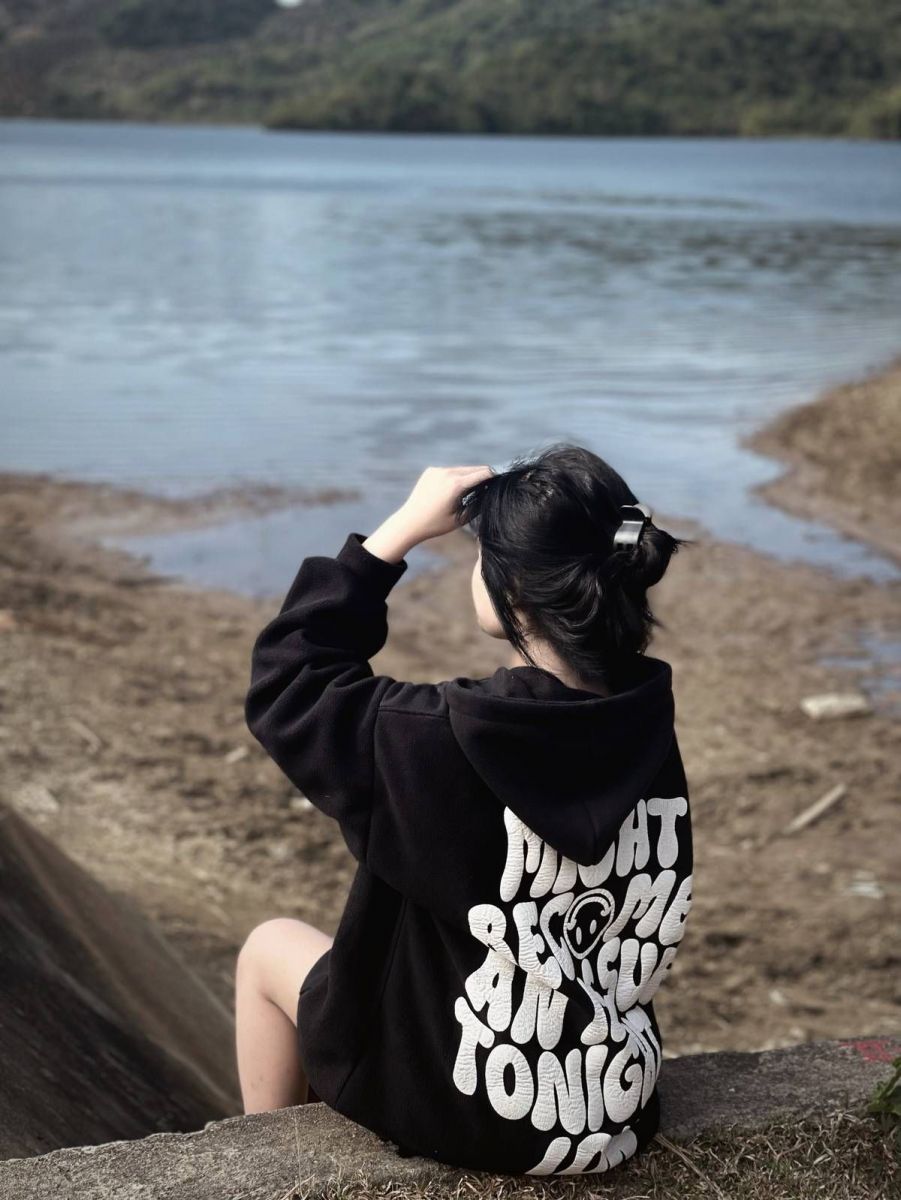 Gái Trẻ Mặc Áo Hoodie Đen Ngồi Bên Bờ Hồ