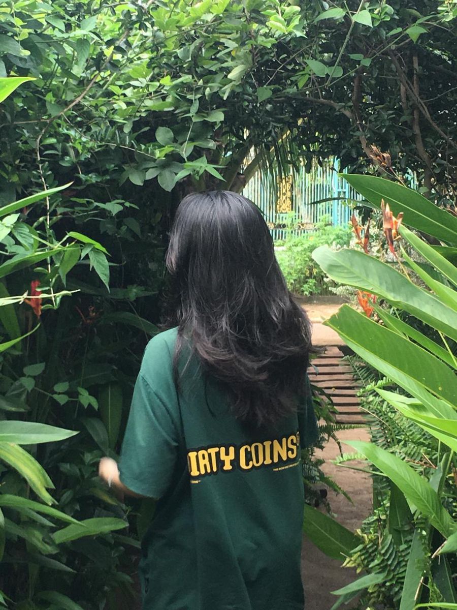 Gái Trẻ Mặc Áo Thun Oversized Màu Xanh Trong Khu Vườn Rậm Cây
