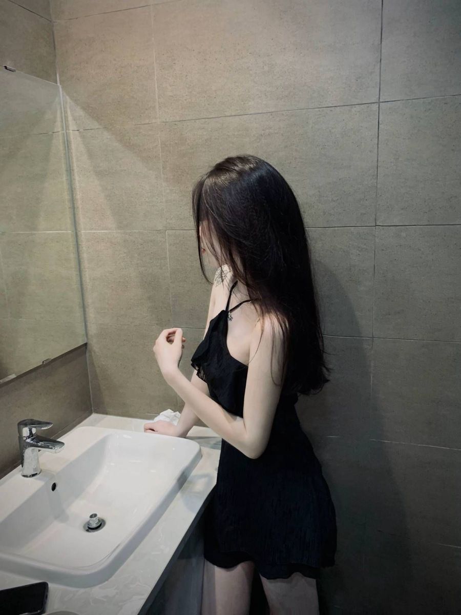 Gái Trẻ Mặc Váy Đen Dùng Bên Bồn Rửa Mặt