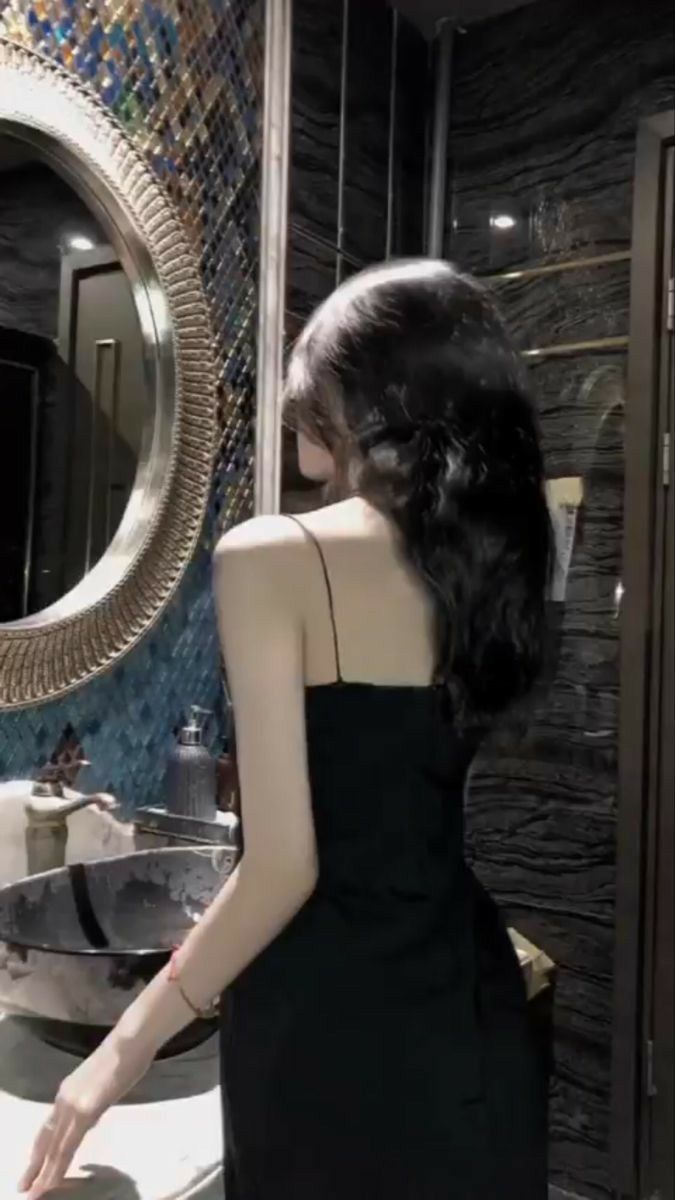 Gái Trẻ Mặc Váy Đen Tự Tin Trước Gương Trong Phòng Tắm Sang Trọng