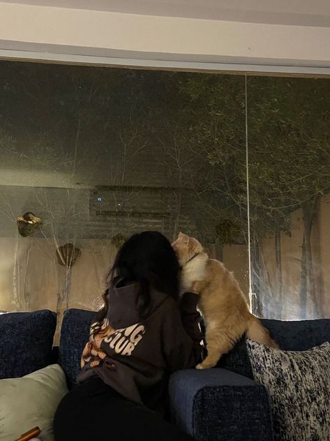 Ảnh cô gái mặc áo hoodie đen ngồi trên ghế sofa