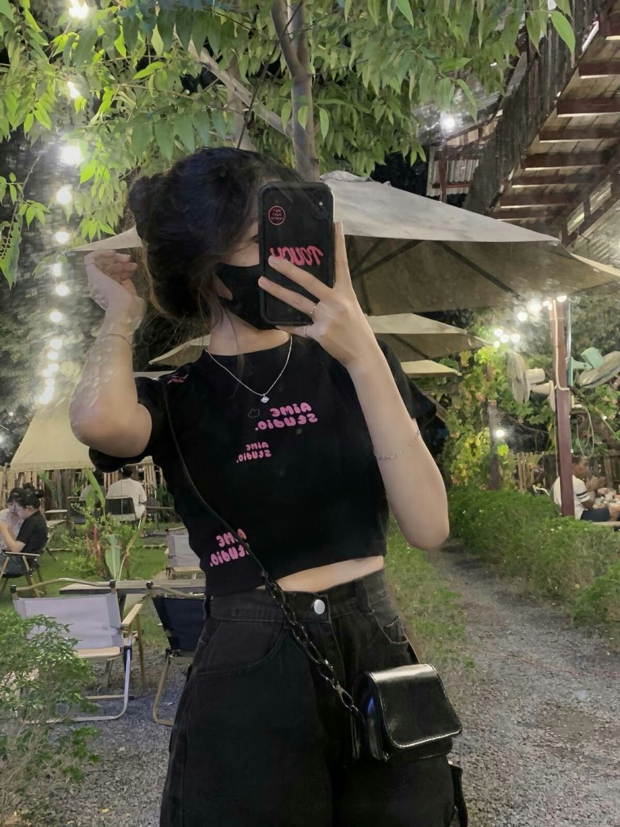 Ảnh cô gái trẻ mặc áo croptop màu đen giữa không gian xanh