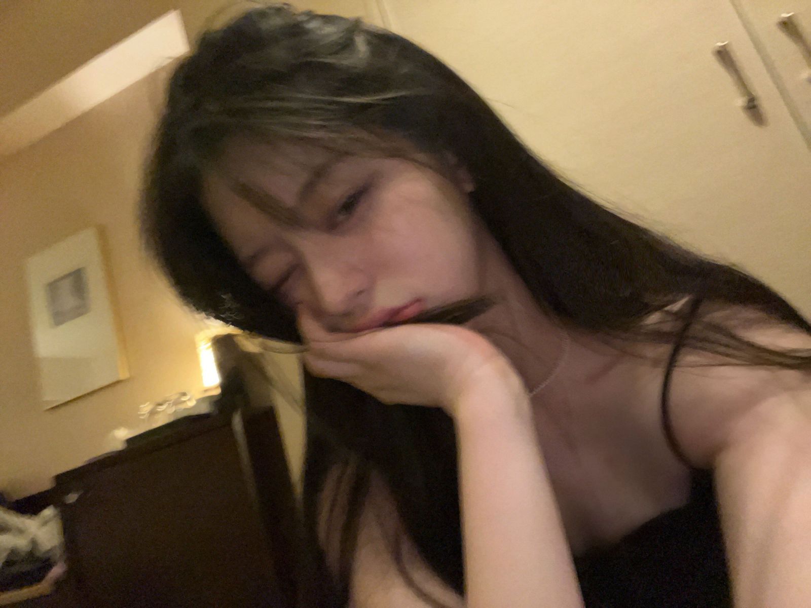 Ảnh cô gái trẻ mặc áo hai dây màu đen trong phòng tối