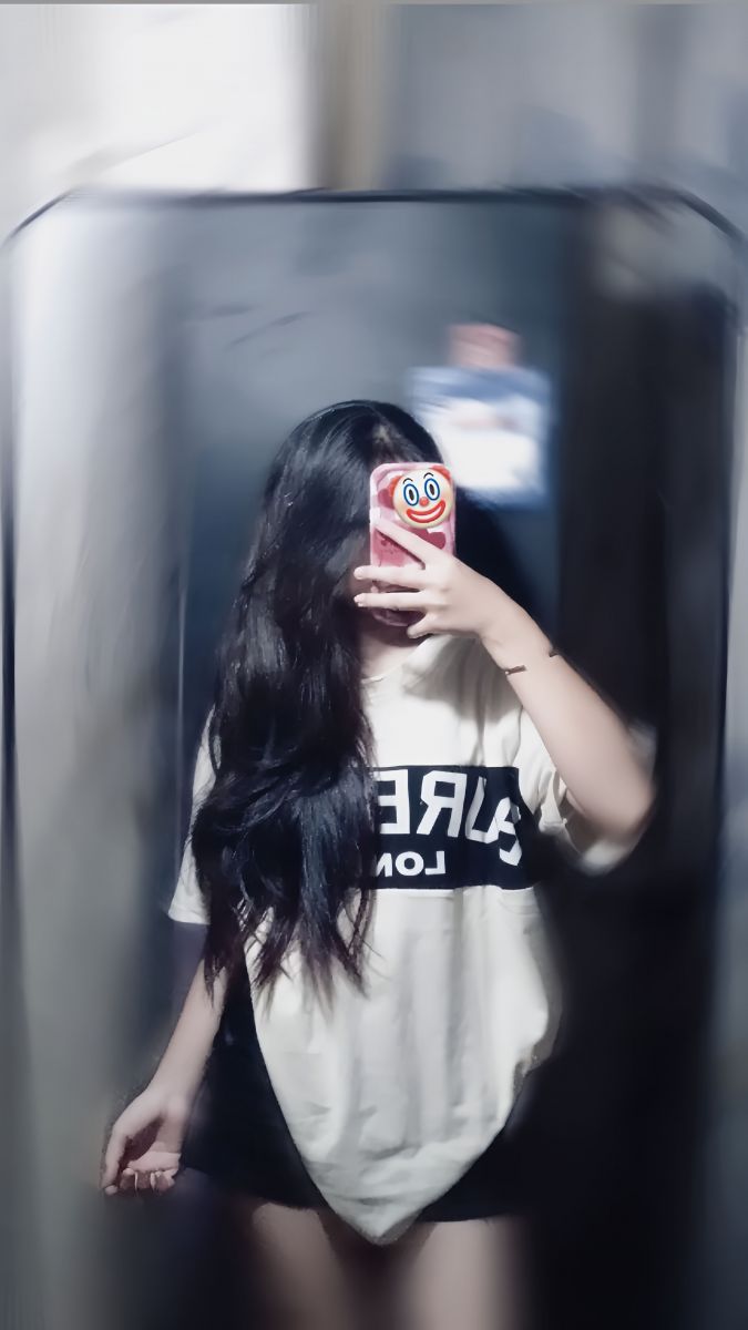 Ảnh cô gái trẻ mặc áo phông trắng đen chụp selfie trong phòng