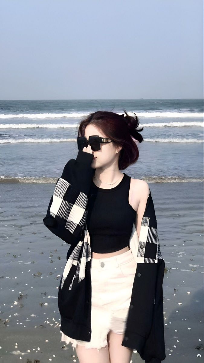 Ảnh gái mặc áo crop top đen và quần short trắng trên bãi biển