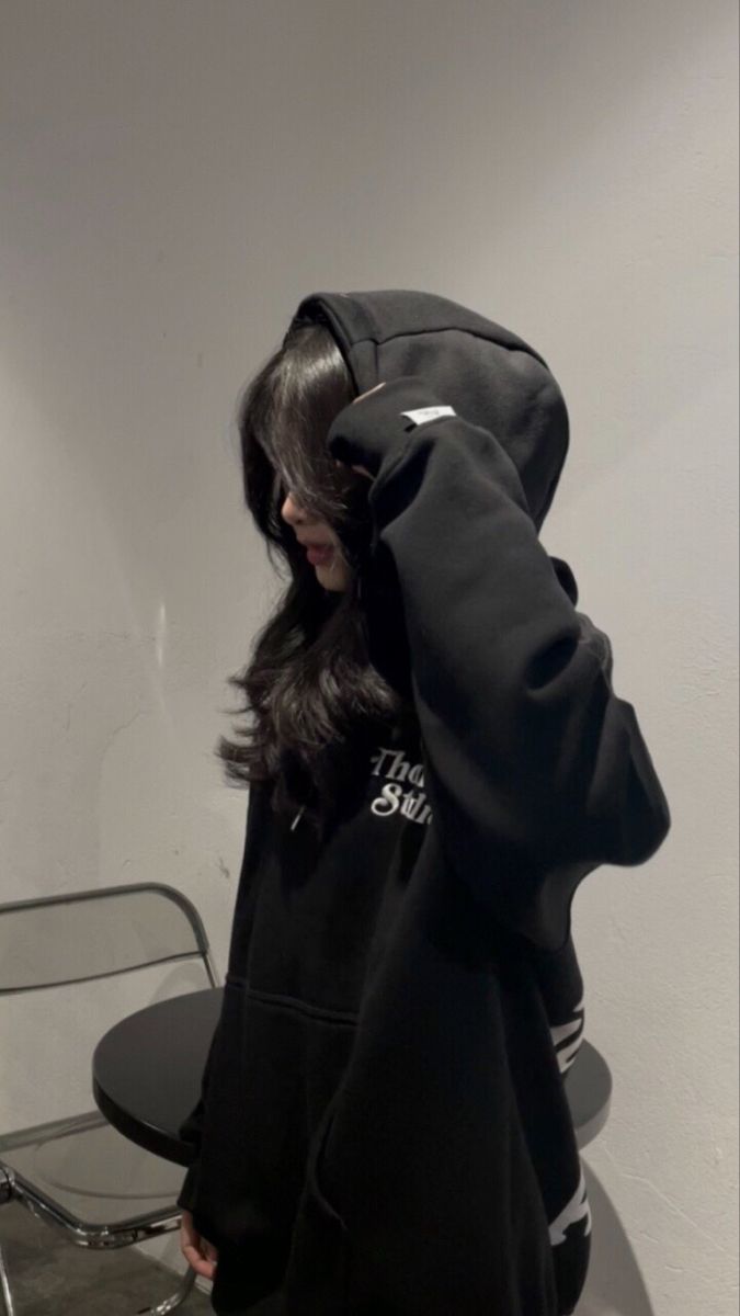 Ảnh gái mặc áo hoodie đen trong không gian nội thất đơn giản