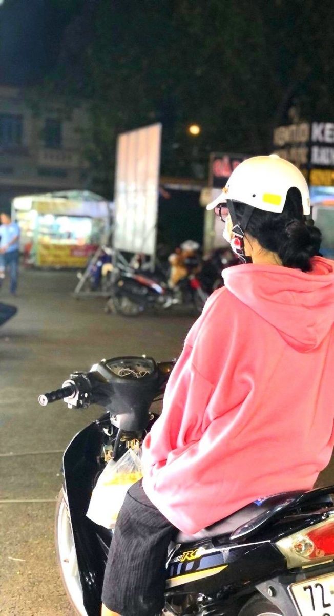 Ảnh gái mặc áo hoodie hồng ngồi trên xe máy giữa đêm phố