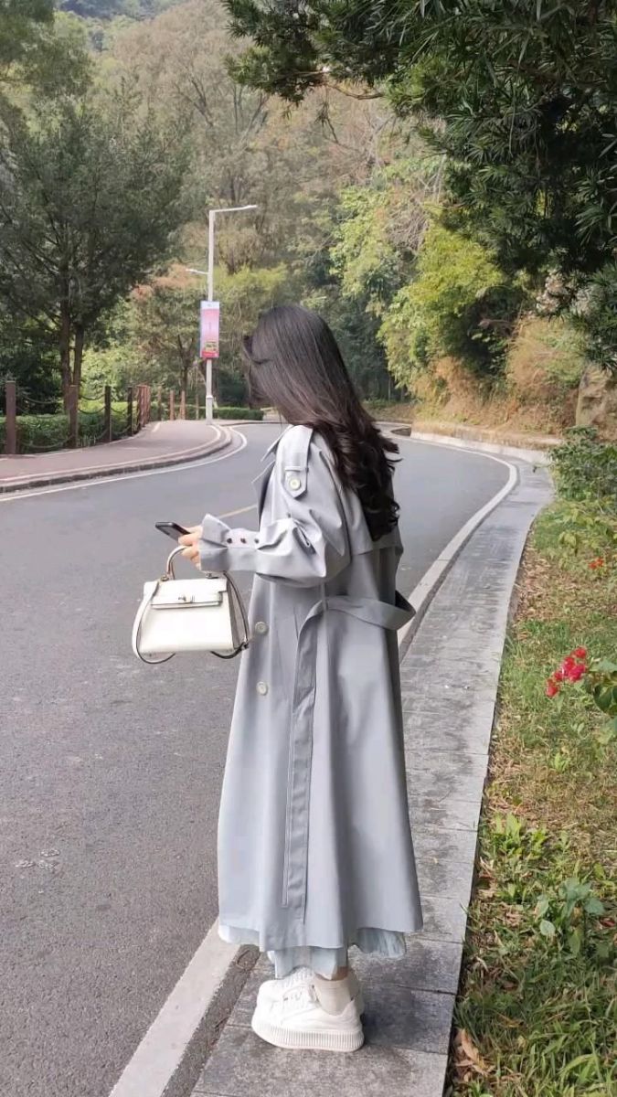 Ảnh gái mặc áo khoác dáng dài màu xám bên đường