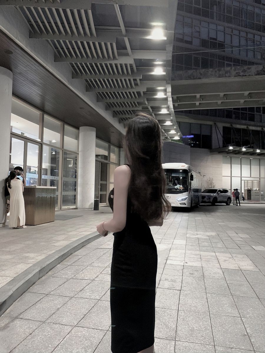Ảnh gái tóc dài mặc đầm đen đứng quay lưng chờ xe