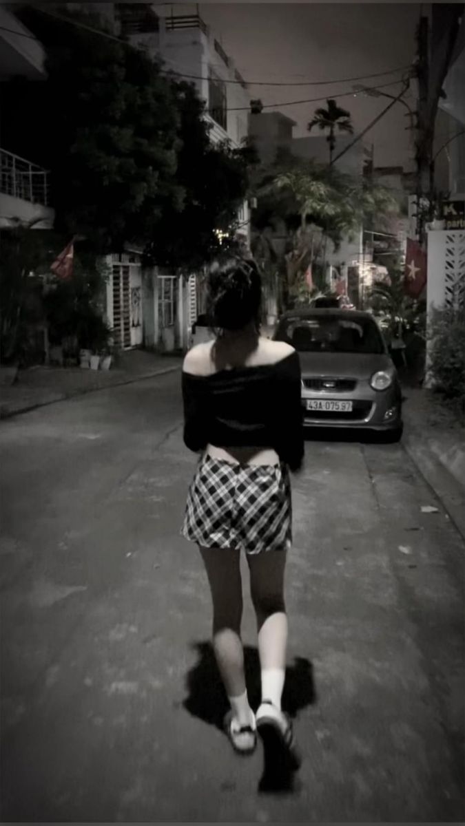 Ảnh gái trẻ mặc áo crop top đen và chân váy dạo phố