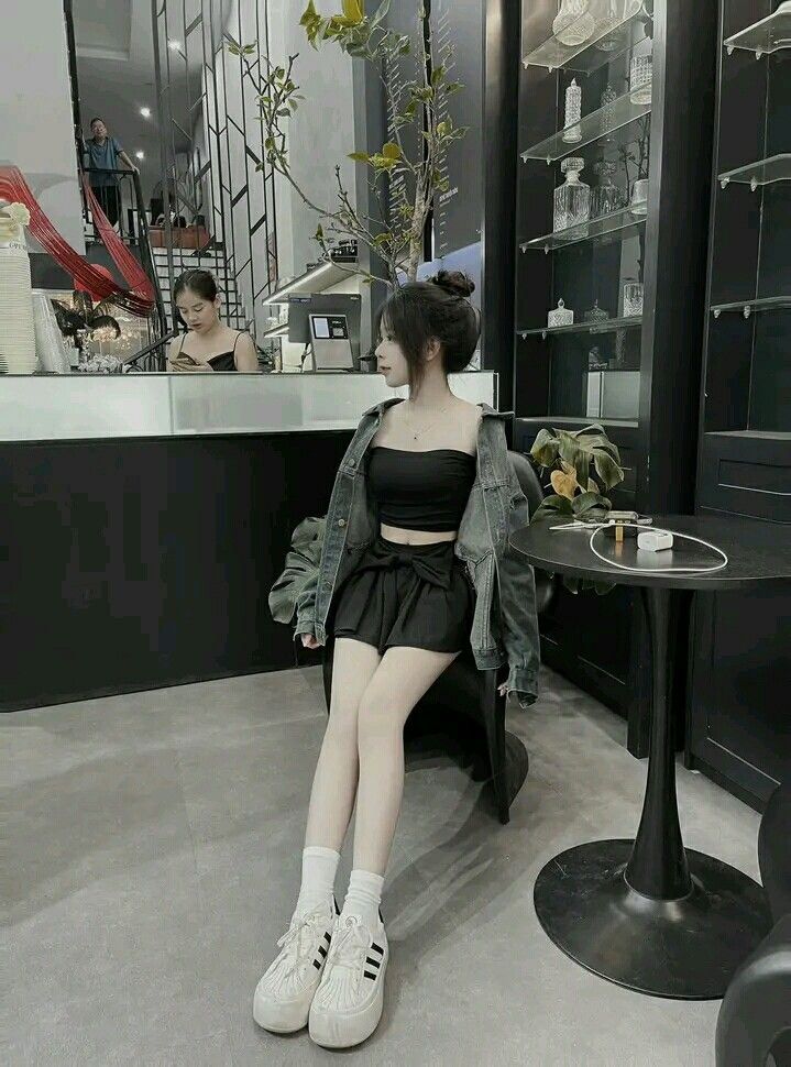 Ảnh gái trẻ mặc áo crop top đen và chân váy ngắn