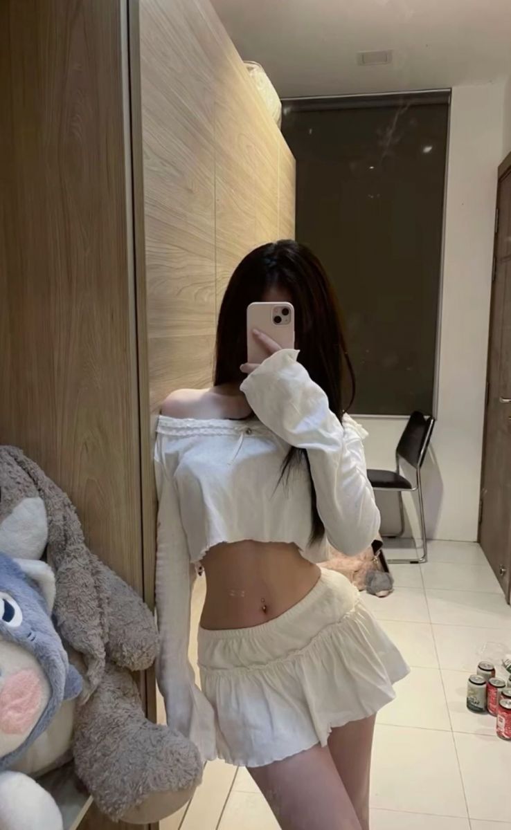 Ảnh gái trẻ mặc áo crop top trắng chụp hình trong phòng