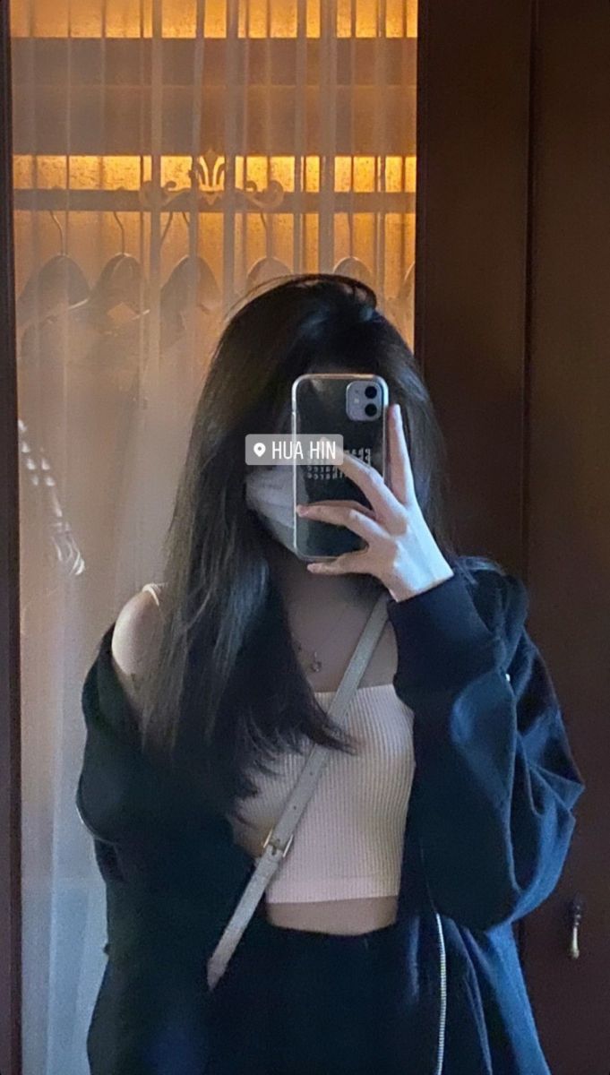 Ảnh gái trẻ mặc áo croptop trắng và áo khoác đen chụp selfie trong gương