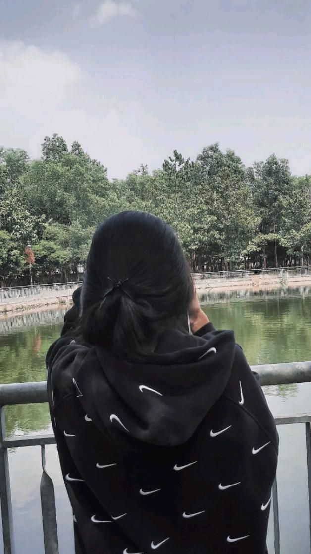 Ảnh gái trẻ mặc áo hoodie đen bên bờ hồ yên tĩnh