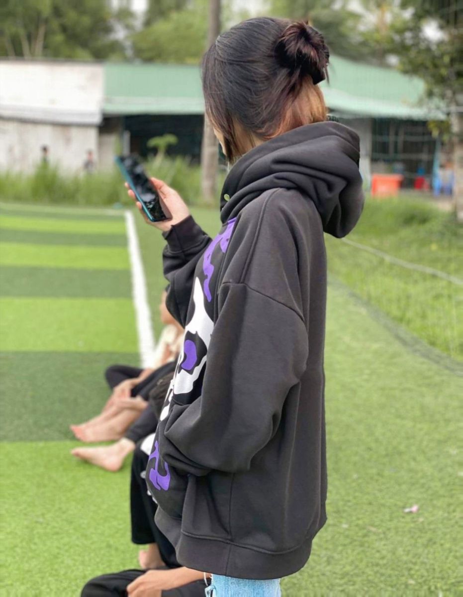 Ảnh gái trẻ mặc áo hoodie đen có hoa tiết tím