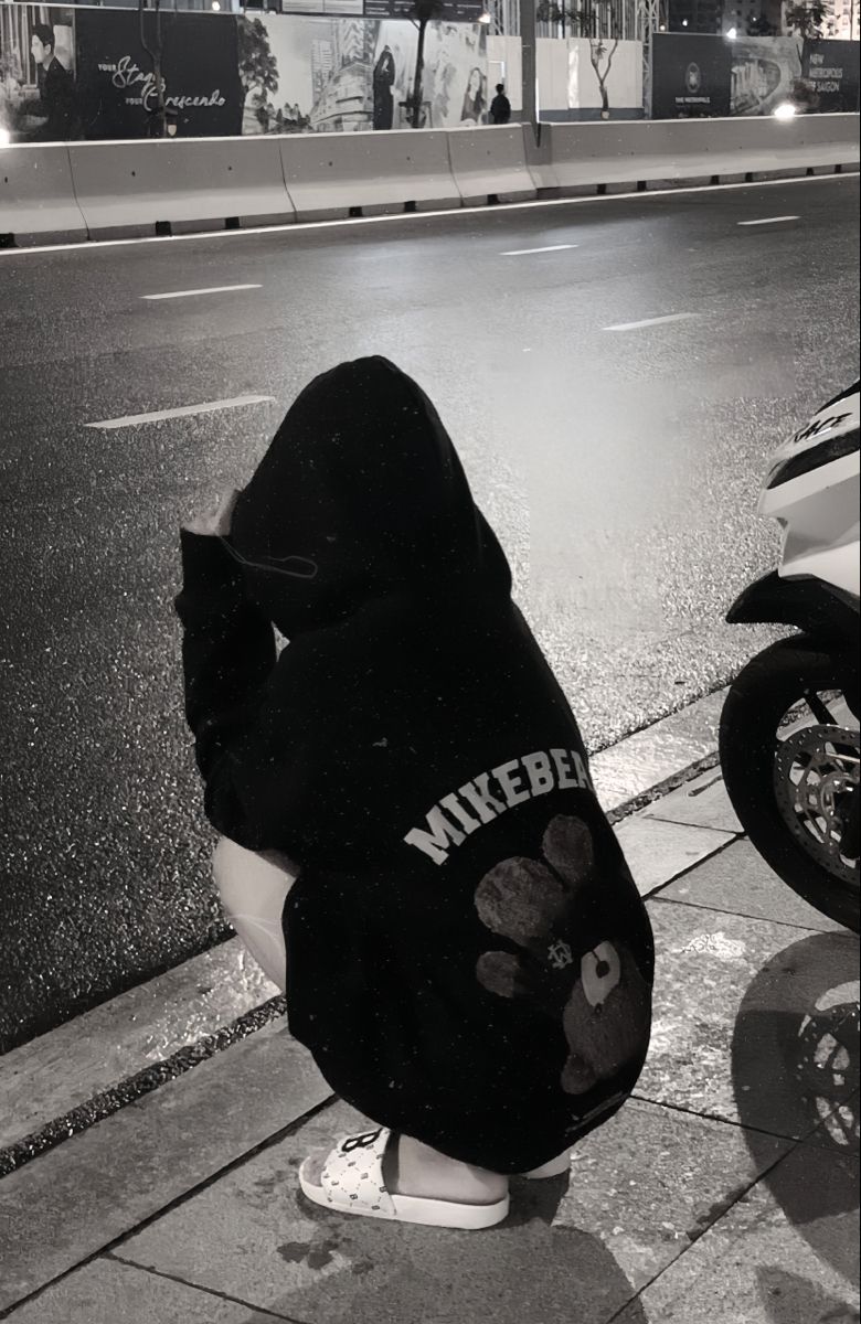 Ảnh gái trẻ mặc áo hoodie đen quyến rũ bên lề đường trời mưa