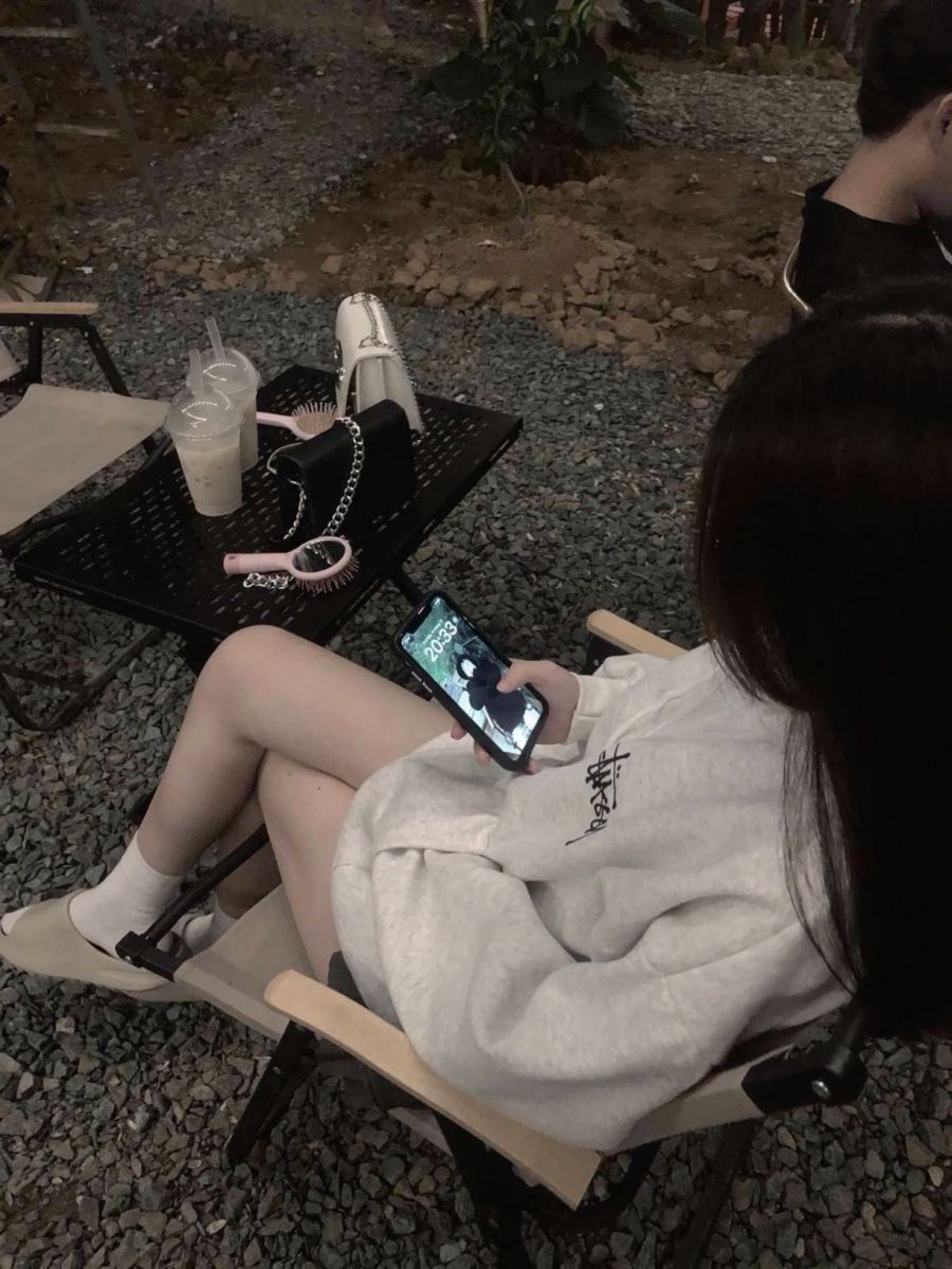 Ảnh gái trẻ mặc áo hoodie ngồi trên ghế